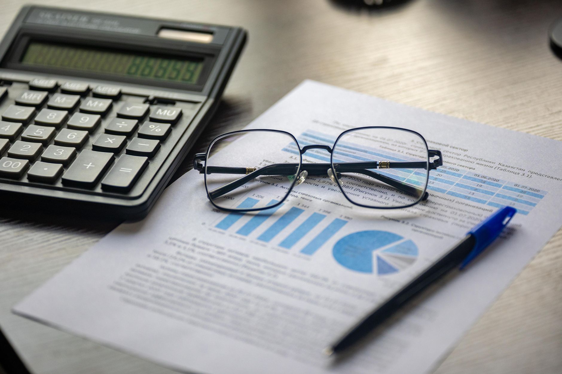Informe financiero con calculadora y lentes sobre un escritorio